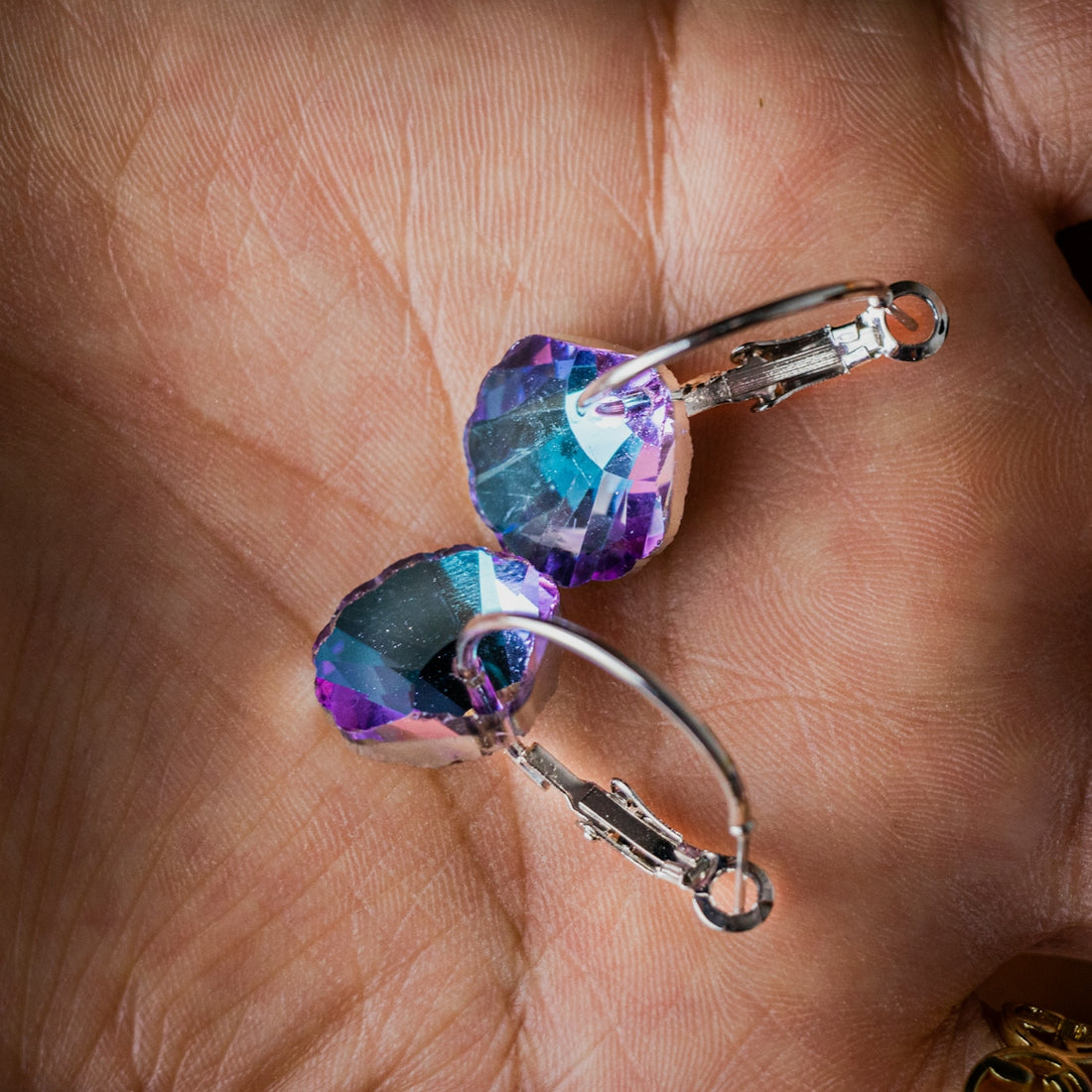 a person holding a pair of earrings in their hand