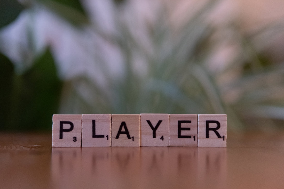 A wooden block spelling the word player on a table