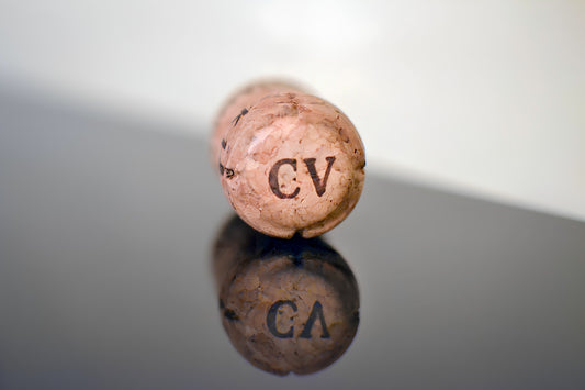 A cork with the letters cv reflects.
