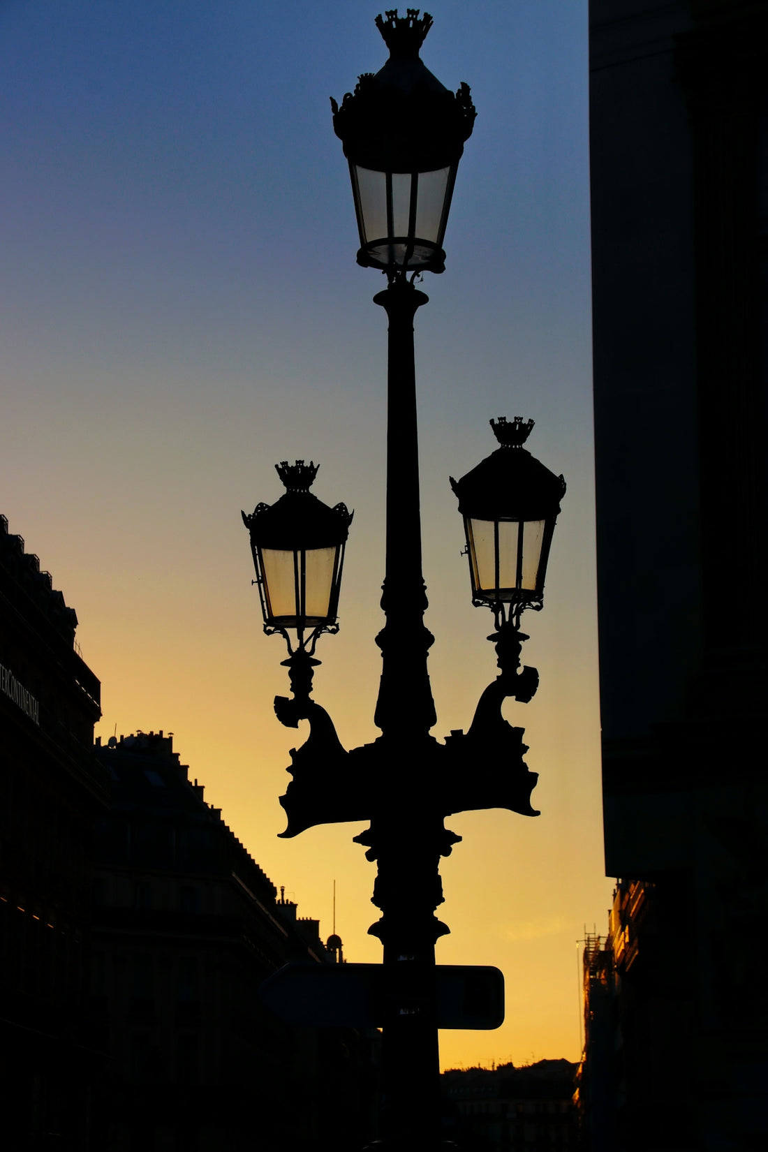 Silhouette of ornate street lamp at sunset