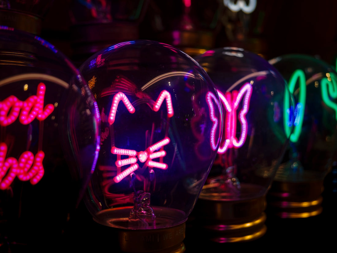 Glass bulbs with neon cat, butterfly, and cactus designs.