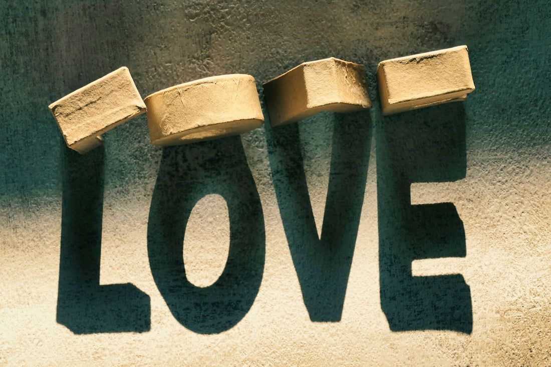 Wooden blocks spell love in shadow on a textured surface
